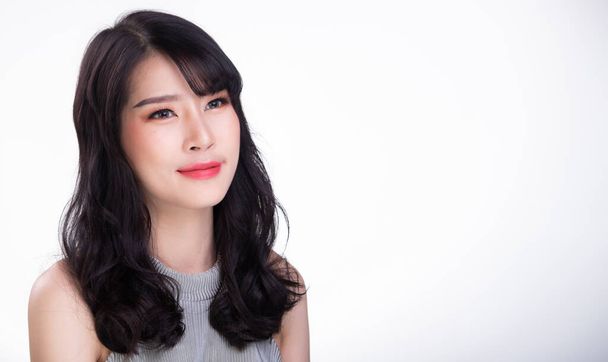 20s aziatische vrouw kijkt naar camera voor portret fotoshoot en glimlach, witte achtergrond geïsoleerde kopieerruimte - Foto, afbeelding