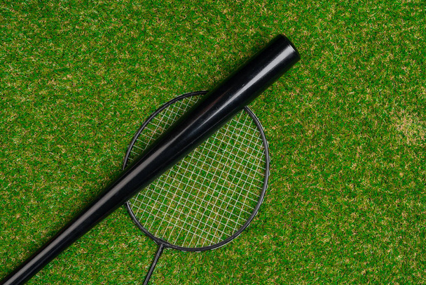 Baseball bat and badminton racket on grass, top view - Foto, Bild