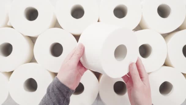 Leżeć płasko. Nowe białe rolki papieru toaletowego na szarym tle. - Materiał filmowy, wideo