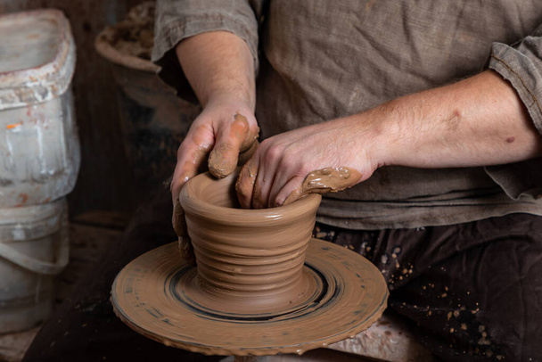 Creating a pot of clay close-up. Hands making products from clay. Potter at work. - Photo, Image