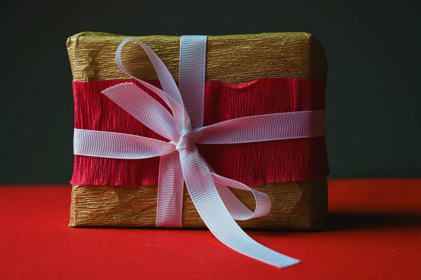 gift box with white ribbon on dark background. High quality photo - Zdjęcie, obraz