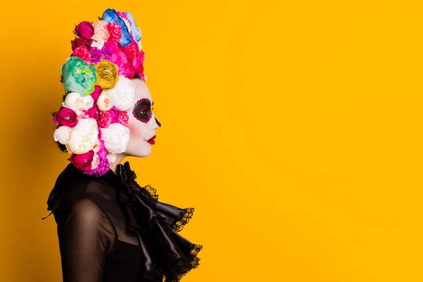 Profile photo of calavera katrina undead bride mourning husband latin cemetery traditional funeral wear black dress death carnival costume roses headband isolated yellow color background - Zdjęcie, obraz
