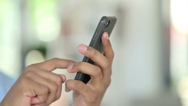 Κοντινό πλάνο του Young African Man χρησιμοποιώντας SMS στο Smartphone - Πλάνα, βίντεο
