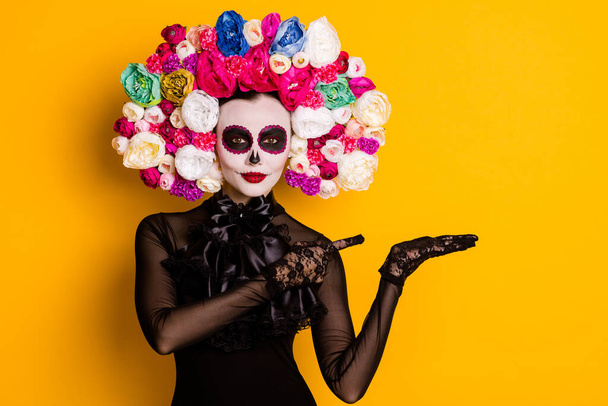 Portrait of her she nice-looking beautiful creepy confident lady holding on palm copy space advert discount Santa Muerte isolated bright vivid shine vibrant yellow color background - 写真・画像