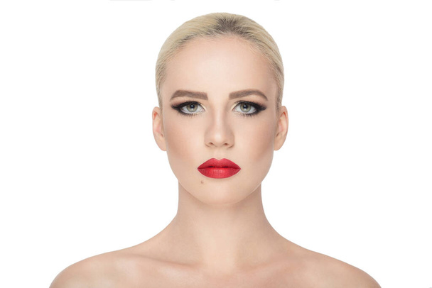 Πορτραίτο. Γυναίκα με τέλειο μακιγιάζ, δραματικά μάτια, κόκκινα χείλη, κοιτάζοντας κάμερα, με γυμνούς ώμους, ισοαλέτ σε λευκό φόντο. - Φωτογραφία, εικόνα