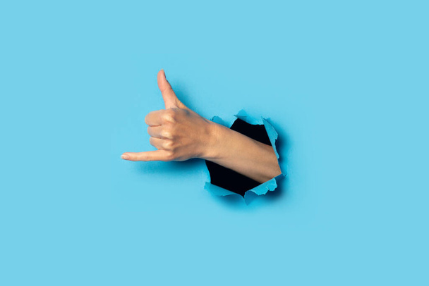 Female hand makes a welcome gesture of surfers on a blue background. Banner. Oloha gesture. - Photo, Image