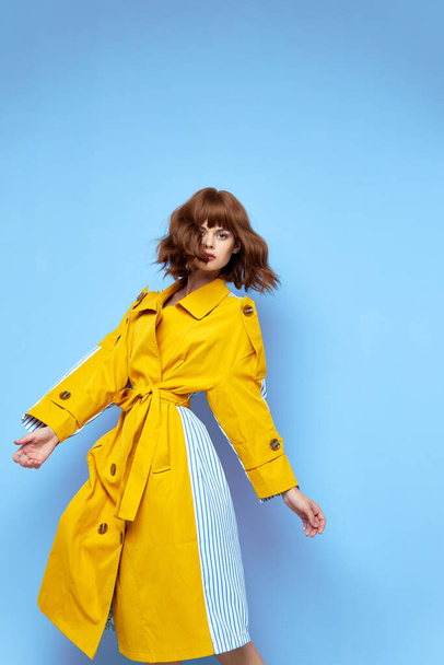 mujer de moda en abrigo amarillo rayas tela morena maquillaje  - Foto, imagen