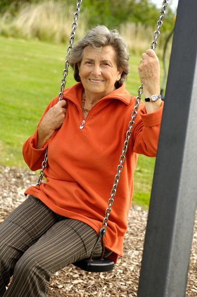 Mujer mayor en un columpio de patio
 - Foto, Imagen