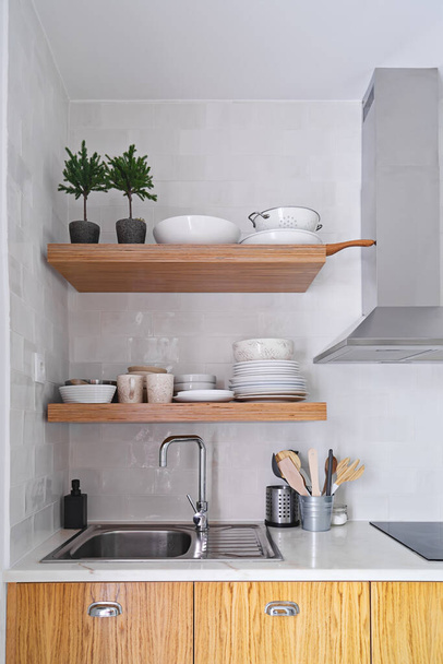 Estantes de cocina de madera con vajilla en la pared de cerámica blanca en estilo escandinavo - Foto, Imagen
