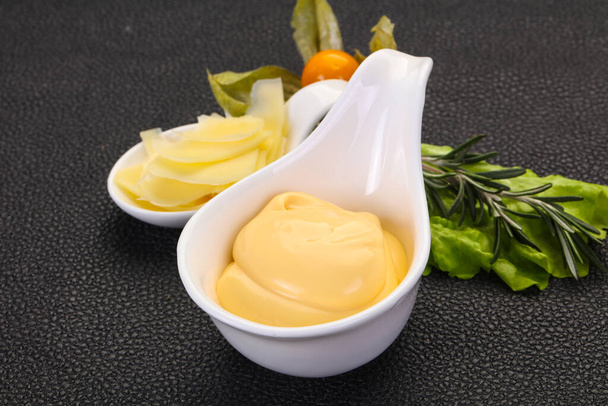 Sauce au fromage dans le bol servi en tranches de parmesan - Photo, image