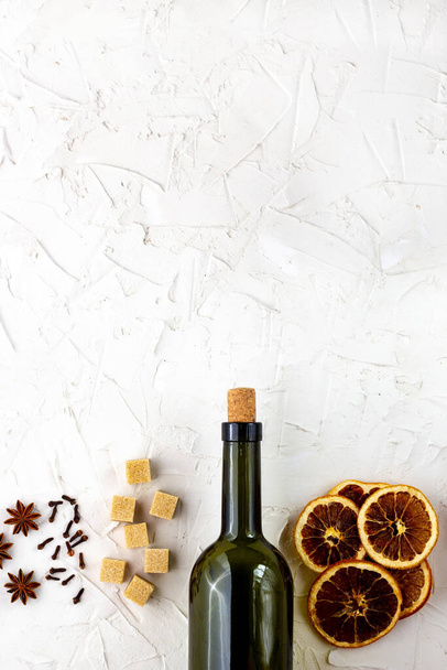 白を基調としたワインとスパイスのボトル。複数のワインの材料。シナモン、アニスの星、オレンジ、黒糖、クローブ。クリスマスホットドリンク - 写真・画像