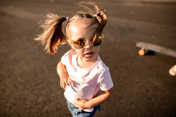 Retrato de niña linda en gafas de sol con dos colas de caballo. - Foto, Imagen