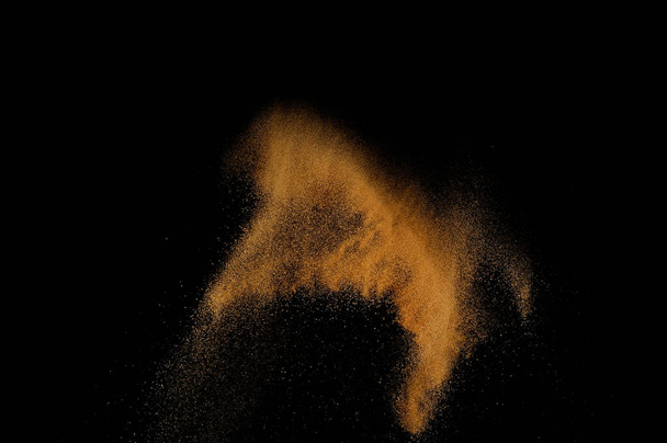 Sandy explosion isolated on black background. Abstract sand cloud. - 写真・画像