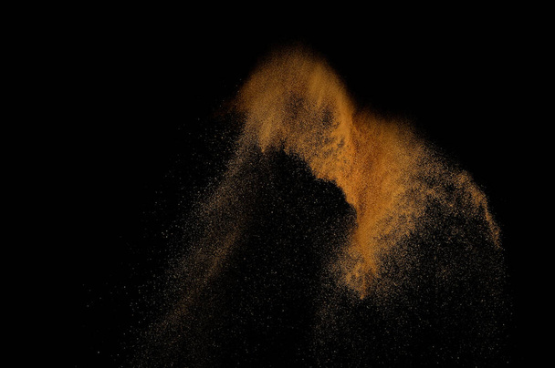 Sandy explosion isolated on black background. Abstract sand cloud. - Foto, afbeelding