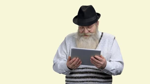 Ηλικιωμένος άνδρας σε καπέλο κρατώντας δισκίο υπολογιστή. - Πλάνα, βίντεο