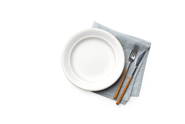 Flat lay white empty plate with blue napkin and cutlery isolated on white background, top view  - Photo, Image