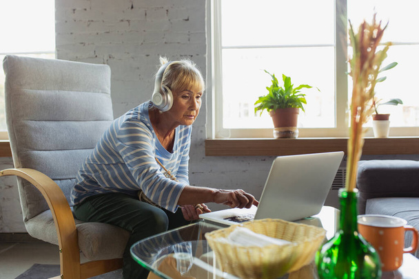 Ηλικιωμένη γυναίκα που σπουδάζει στο σπίτι, να πάρει online μαθήματα - Φωτογραφία, εικόνα