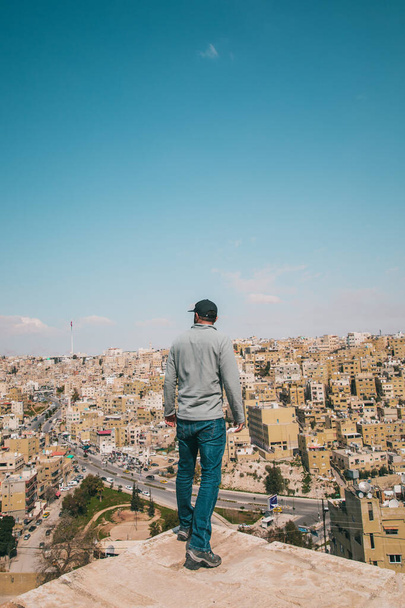 Orta Doğu 'da Amman, Ürdün' ün şehir manzarasının önünde gülümseyen bir adam. - Fotoğraf, Görsel