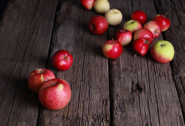 Red apples on rough rustic old wooden board. Closeup view. Natural organic food, healthy eating, harvest season concept - Fotó, kép