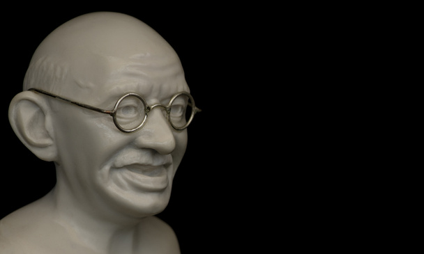 Közelkép Mahatma Gandhi mellszobráról, egyszerű fehér háttérrel, negatív idézőjellel.. - Fotó, kép
