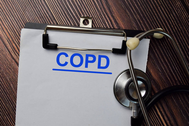 木製のテーブルに隔離された書類にCOPDの書き込み. - 写真・画像