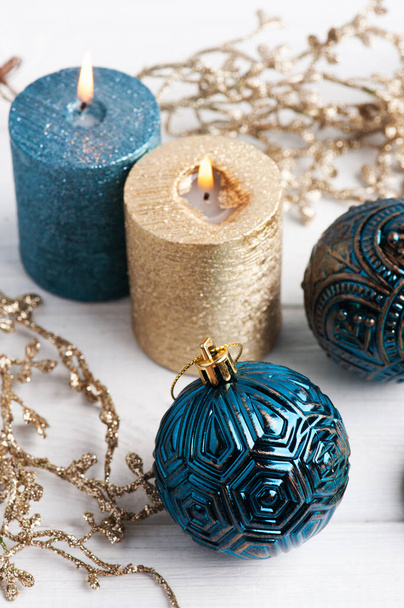Kék golyók, arany illatú gyertyák és karácsonyi játékok fából készült rusztikus háttérrel. Téli készlet fénymásolási hellyel - Fotó, kép