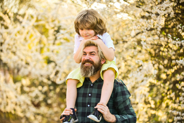 Having fun together. love concept. Cheerful father playing with child in park. Handsome dad with little cute son. enjoy bloom and nature together. happy family day. spring is coming. just have fun - Photo, image