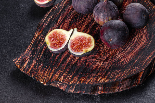 Fresh ripe figs on dark table. Healthy mediterranean fig fruit. Fresh figs on black background - Photo, Image