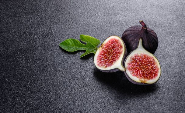 Fresh ripe figs on dark table. Healthy mediterranean fig fruit. Fresh figs on black background - Photo, Image