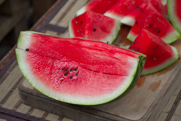 Fresh red ripe watermelon on wooden cutting board, picnic concept, selective focus - Foto, imagen