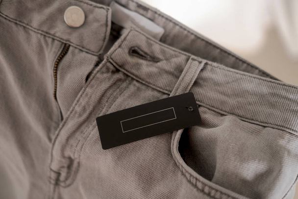Odzież w czarnym kolorze na szarej tkaninie dżinsów. Marka moda makieta - Zdjęcie, obraz