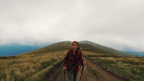 Νεαρή κοπέλα τουρίστρια στο μονοπάτι στα βουνά - Πλάνα, βίντεο
