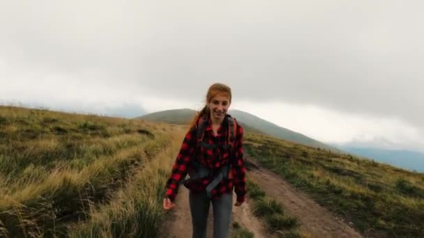 Young girl tourist on the trail in mountains - Filmati, video