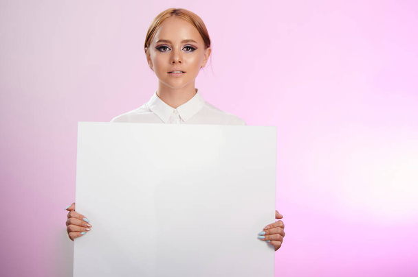 Mujer mostrando letrero blanco aislado sobre fondo rosa estudio - Foto, Imagen