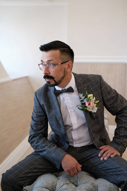 the groom is waiting for the bride. Fashionable man with beard and mustaches dressed expensive suit and glasses. Concept of wedding. - Φωτογραφία, εικόνα