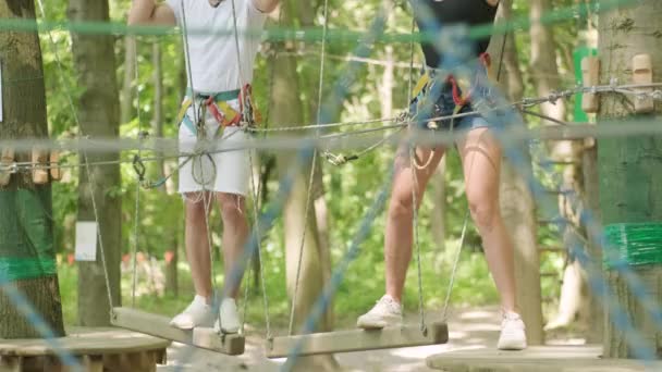 Adventure climbing high wire park - osoby na kursie w hełmie górskim i sprzęcie bezpieczeństwa - Materiał filmowy, wideo