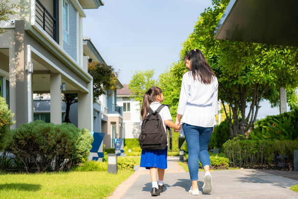 Glückliche asiatische Mutter und Tochter Grundschüler zu Fuß zur Schule am Morgen Schulalltag für Tag im Leben immer bereit für die Schule. - Foto, Bild