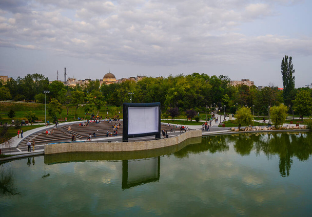 Η ταινία κάτω από τα αστέρια εκδήλωση, που δημιουργήθηκε από το δημαρχείο στο πάρκο Moghiorosh. Μπορείτε να δείτε μια οθόνη προβολής και τους ανθρώπους που περιμένουν για να ξεκινήσει - Φωτογραφία, εικόνα