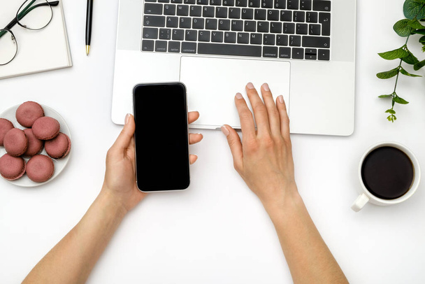 Woman is using smartphone with blank screen over white office desk - Φωτογραφία, εικόνα