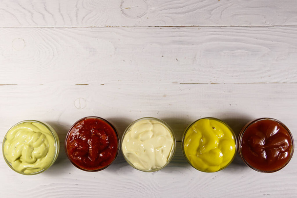 Set de salsas sobre mesa de madera blanca. Vista superior, espacio de copia - Foto, imagen