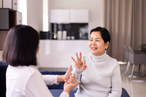 Sign language specialist talking with mature patient deaf hearing and showing hands gesture - Foto, Imagen