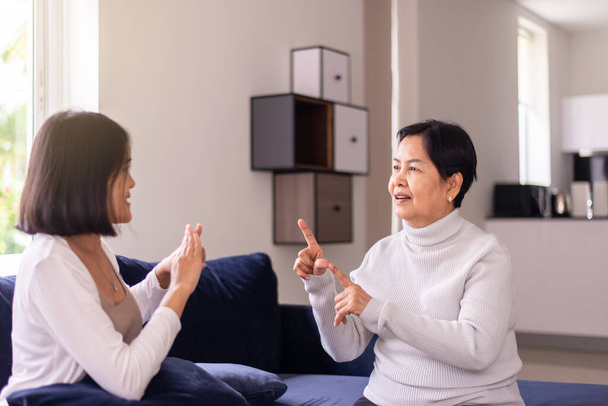 Sign language specialist talking with senior patient deaf hearing and showing hands gesture - Foto, imagen