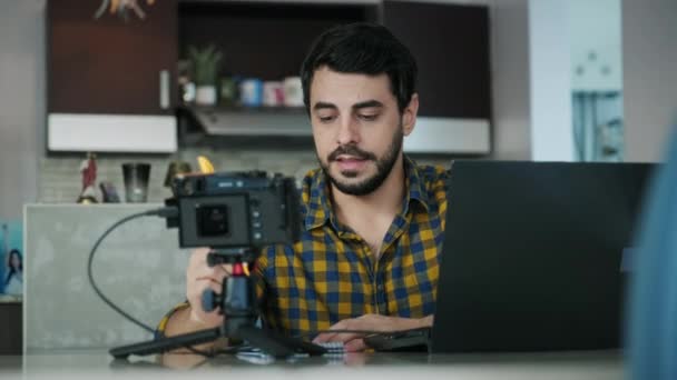 Portret van een Spaanse man die thuis vergadert of een webconferentie houdt. Blanken die op afstand werken of leren. Jonge latino zakenman werken of studeren met laptop pc en camera - Video
