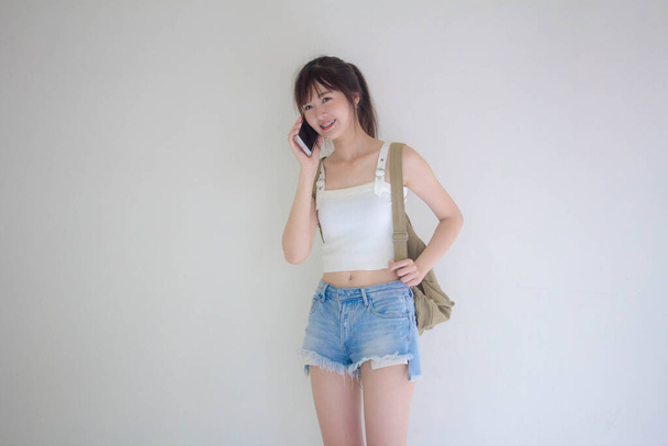 Beautiful Thai girl tourists scottish White shirt blue jeans calling smart phone - Foto, Bild