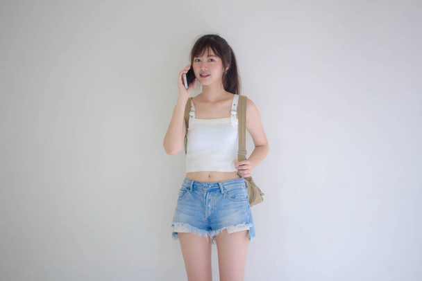Beautiful Thai girl tourists scottish White shirt blue jeans calling smart phone - Foto, Imagem