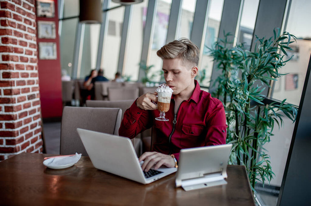 Chlápek sedící u stolu a pracující u laptopu - Fotografie, Obrázek