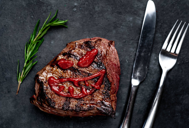 grillezett steak ijesztő arccal ketchupból - Fotó, kép