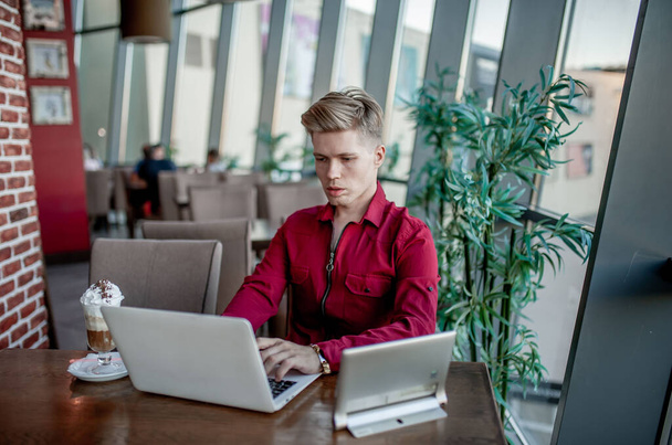 Chlápek sedící u stolu a pracující u laptopu - Fotografie, Obrázek