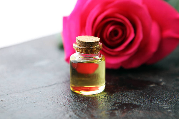 růžová růžová květina a sklenice silice. lázeňská a aromaterapeutická kosmetická koncepce na pozadí - Fotografie, Obrázek