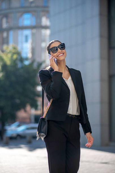Elegant dark-haired woman talking on the phone - Фото, изображение